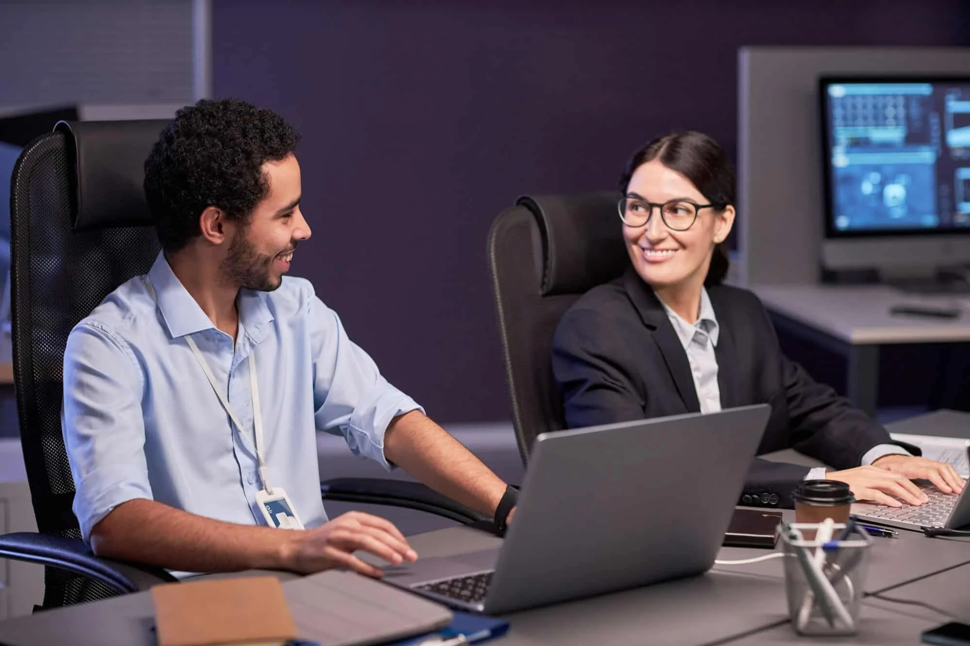 Two smiling business people discussing project in meeting.webp